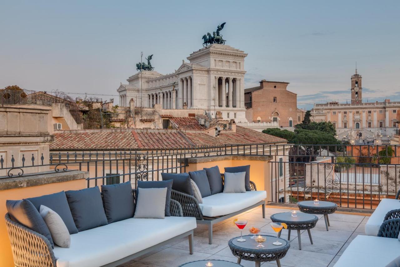 een balkon met banken en tafels en uitzicht op de stad bij Otivm Hotel in Rome