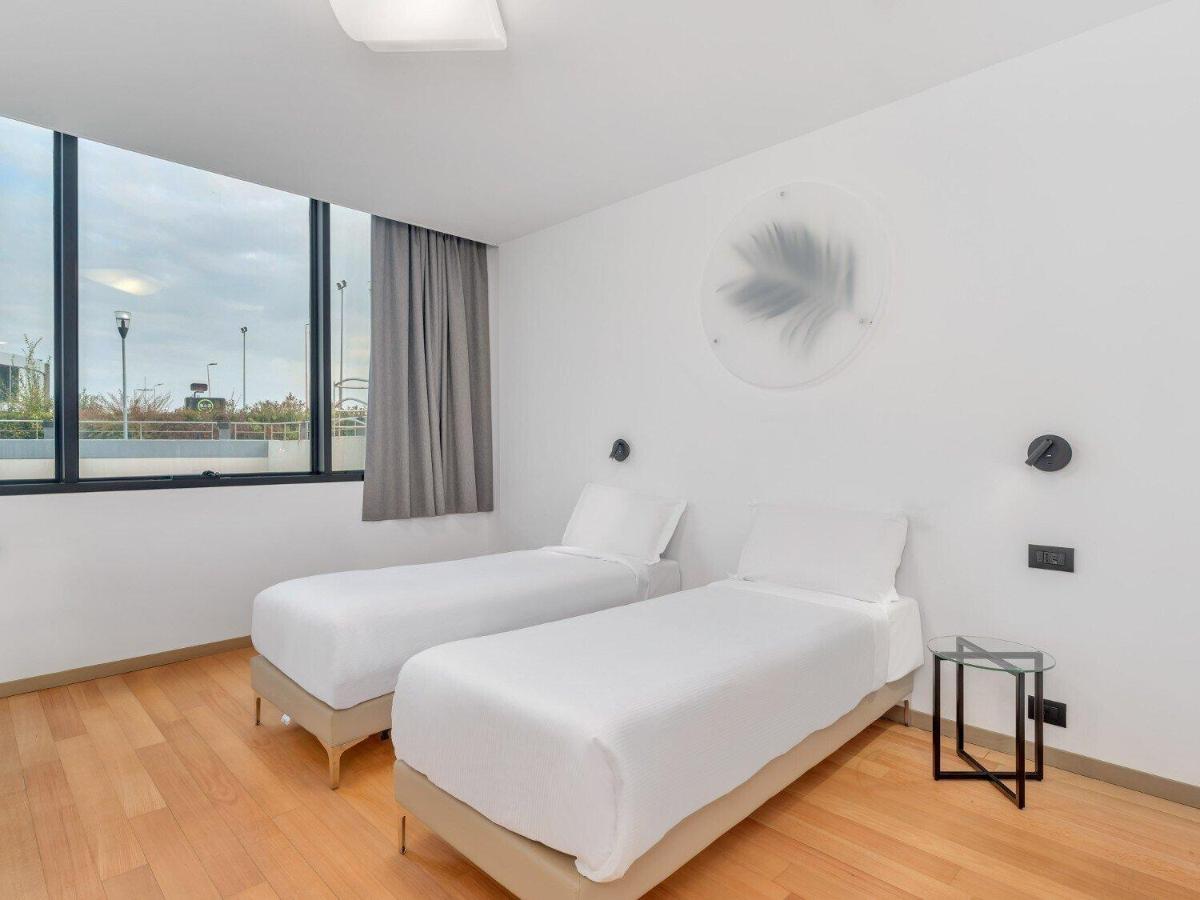 twee bedden in een witte kamer met ramen bij B&B HOTEL Alba in Alba