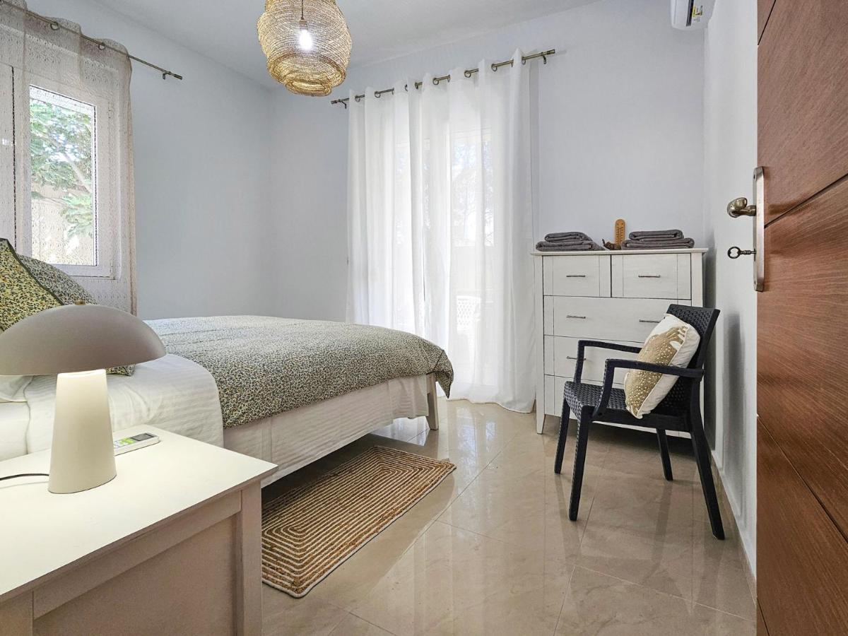 een slaapkamer met een bed, een bureau en een stoel bij Dafne Almyrida Beach Apartment in Almirida