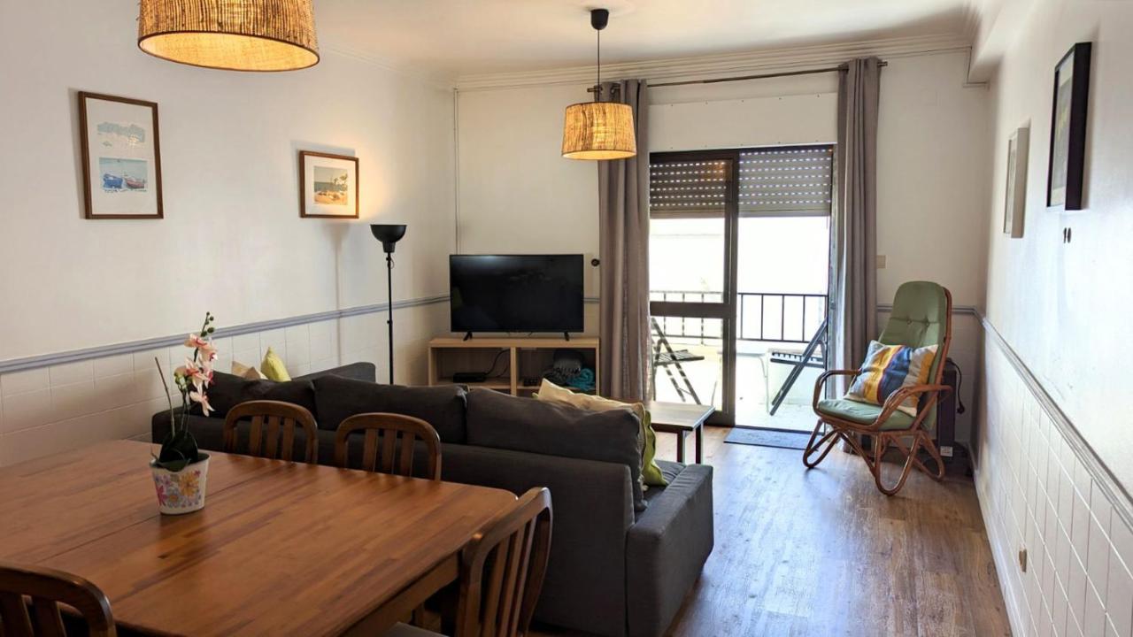 een woonkamer met een bank en een tafel bij Ericeira Holidays in Ericeira