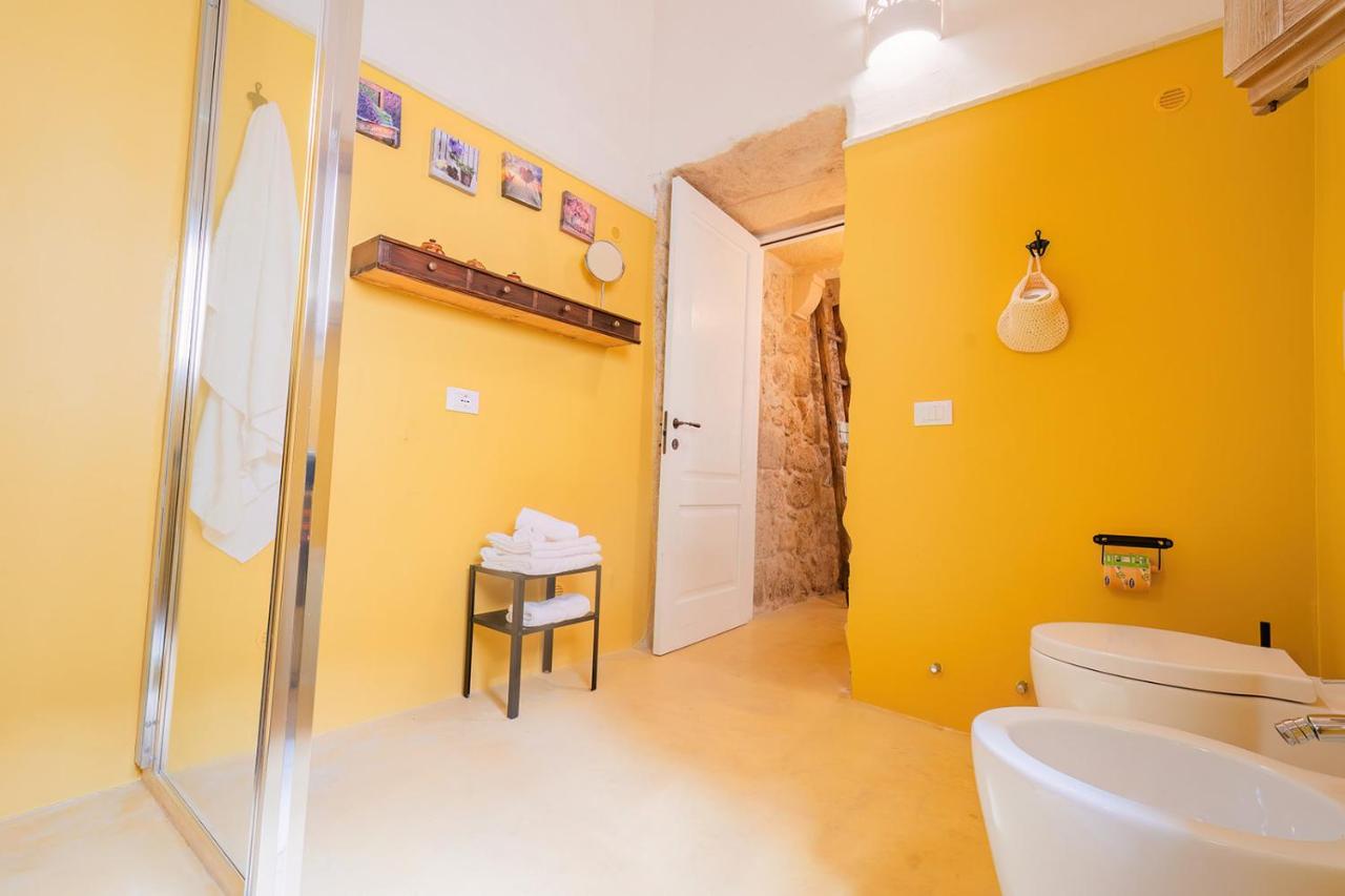 een gele badkamer met een toilet en een wastafel bij HISTORIA- Dimore Corte Chiesa in Corigliano dʼOtranto