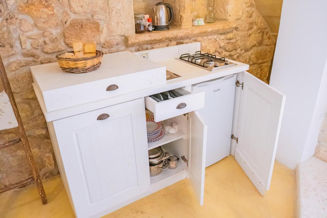 een keuken met witte kasten en een fornuis bij HISTORIA- Dimore Corte Chiesa in Corigliano dʼOtranto