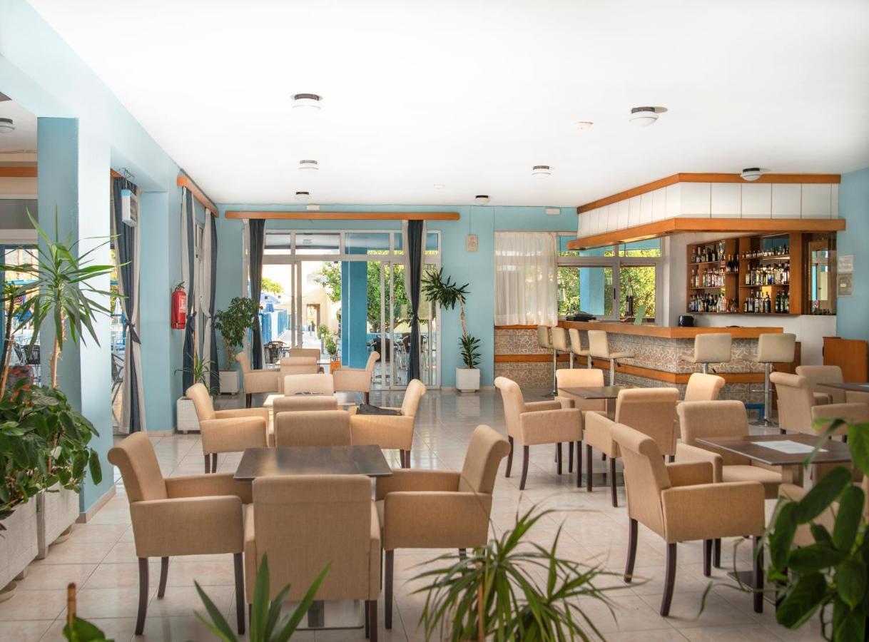 een restaurant met tafels en stoelen in een lobby bij Oasis Tigaki in Tigaki