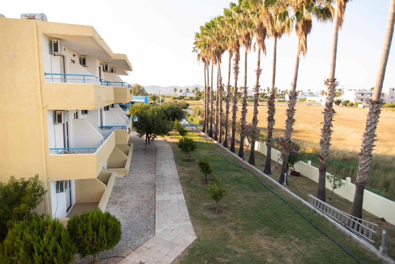 een appartementencomplex met palmbomen ervoor bij Oasis Tigaki in Tigaki