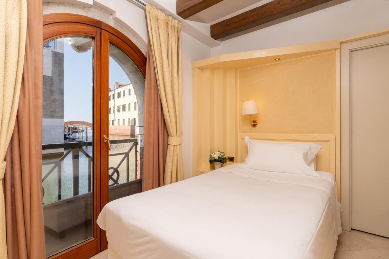 een slaapkamer met een bed en een balkon bij Hotel Giudecca Venezia in Venetië