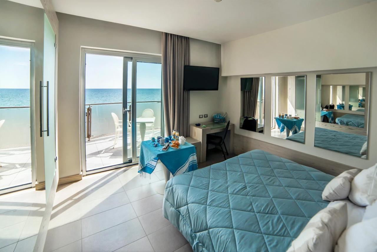 een slaapkamer met een bed en uitzicht op de oceaan bij Smy Aran Blu Roma Mare in Lido di Ostia