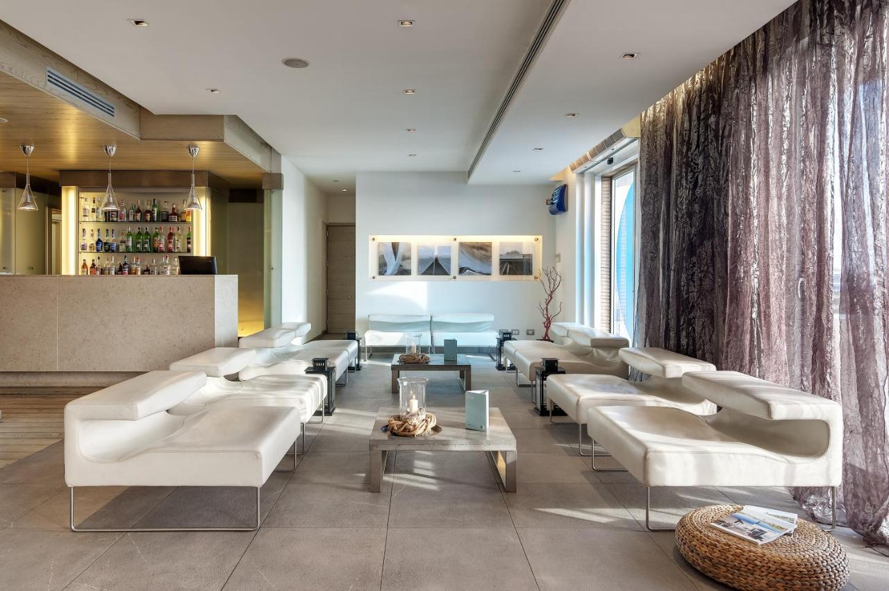een woonkamer met witte banken en een bar bij Smy Aran Blu Roma Mare in Lido di Ostia