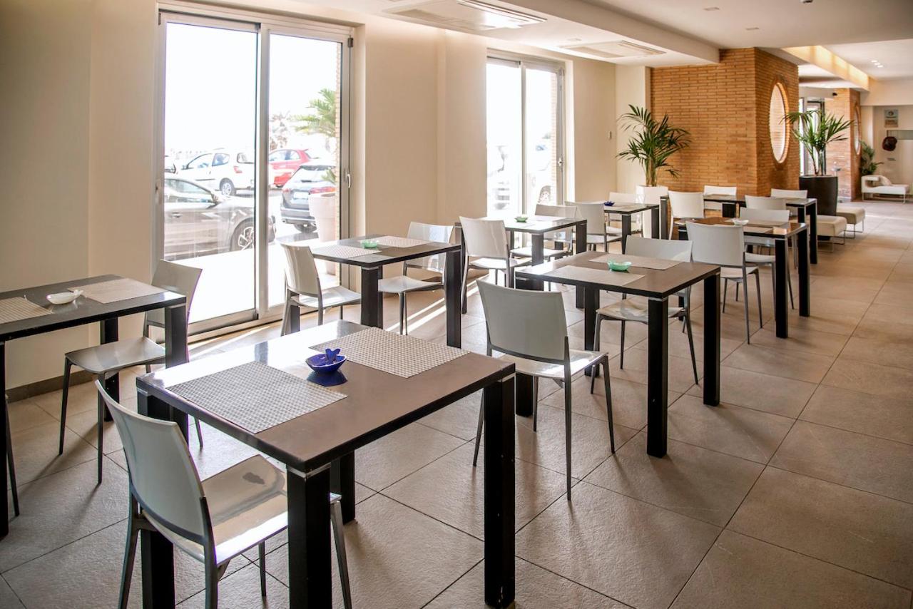 een eetzaal met tafels en stoelen in een restaurant bij Smy Aran Blu Roma Mare in Lido di Ostia