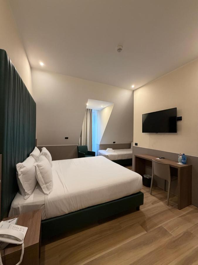 een hotelkamer met een bed en een televisie bij JR Hotels Bocconi Milano in Milaan