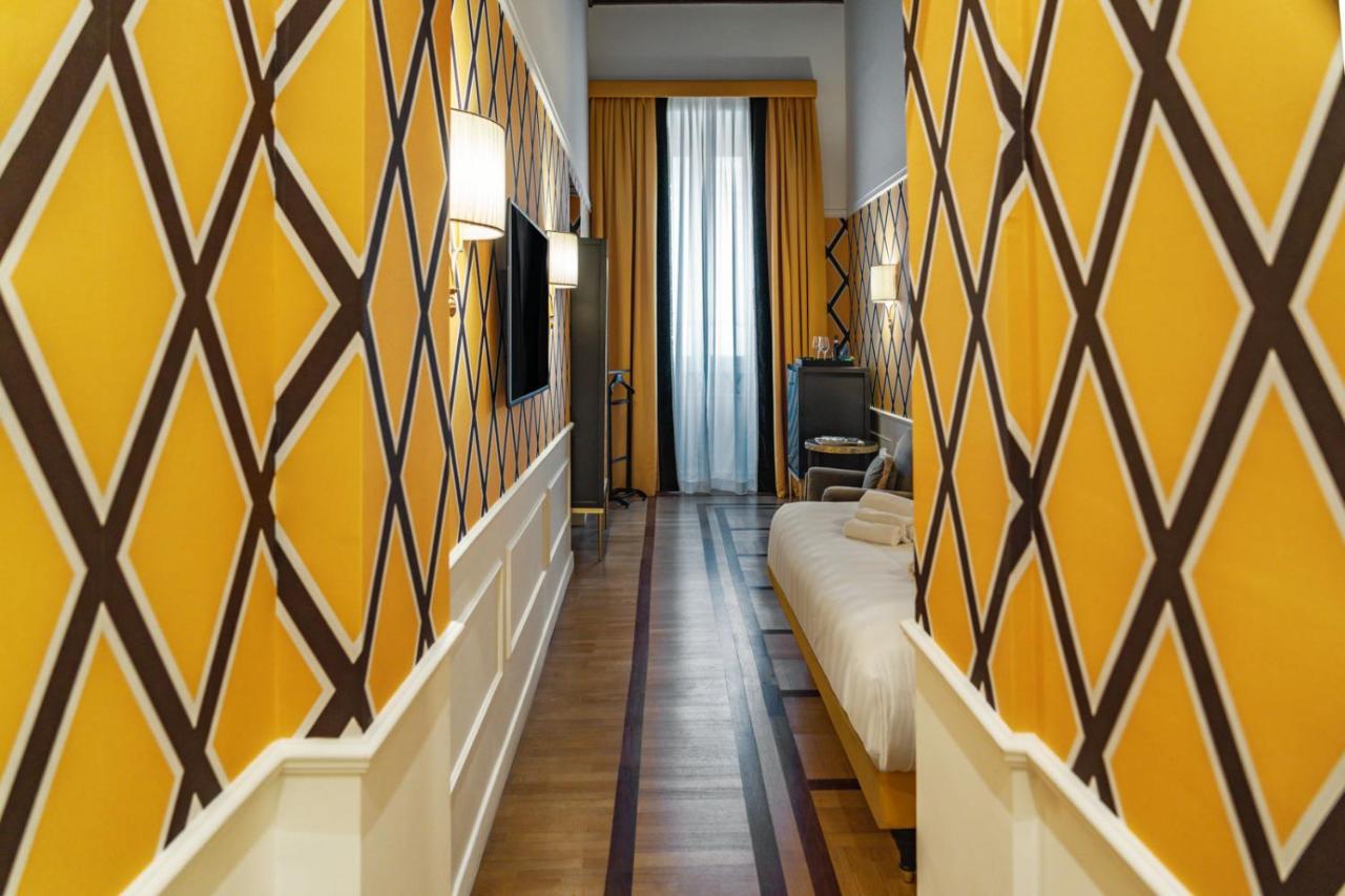 een hotelkamer met gele muren en een bank bij Il Campo Marzio in Rome +70 foto's
