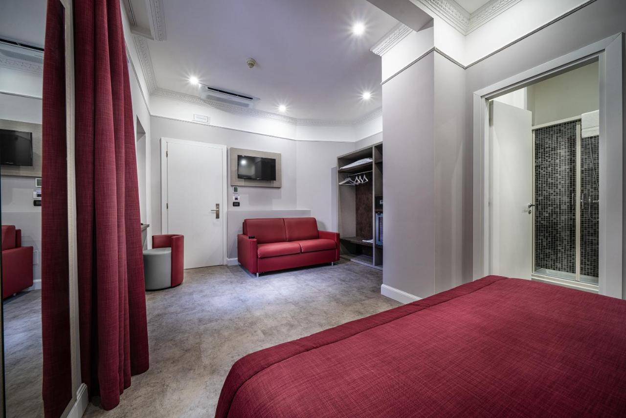 een slaapkamer met een rood bed en een rode bank bij Hotel Varese in Rome