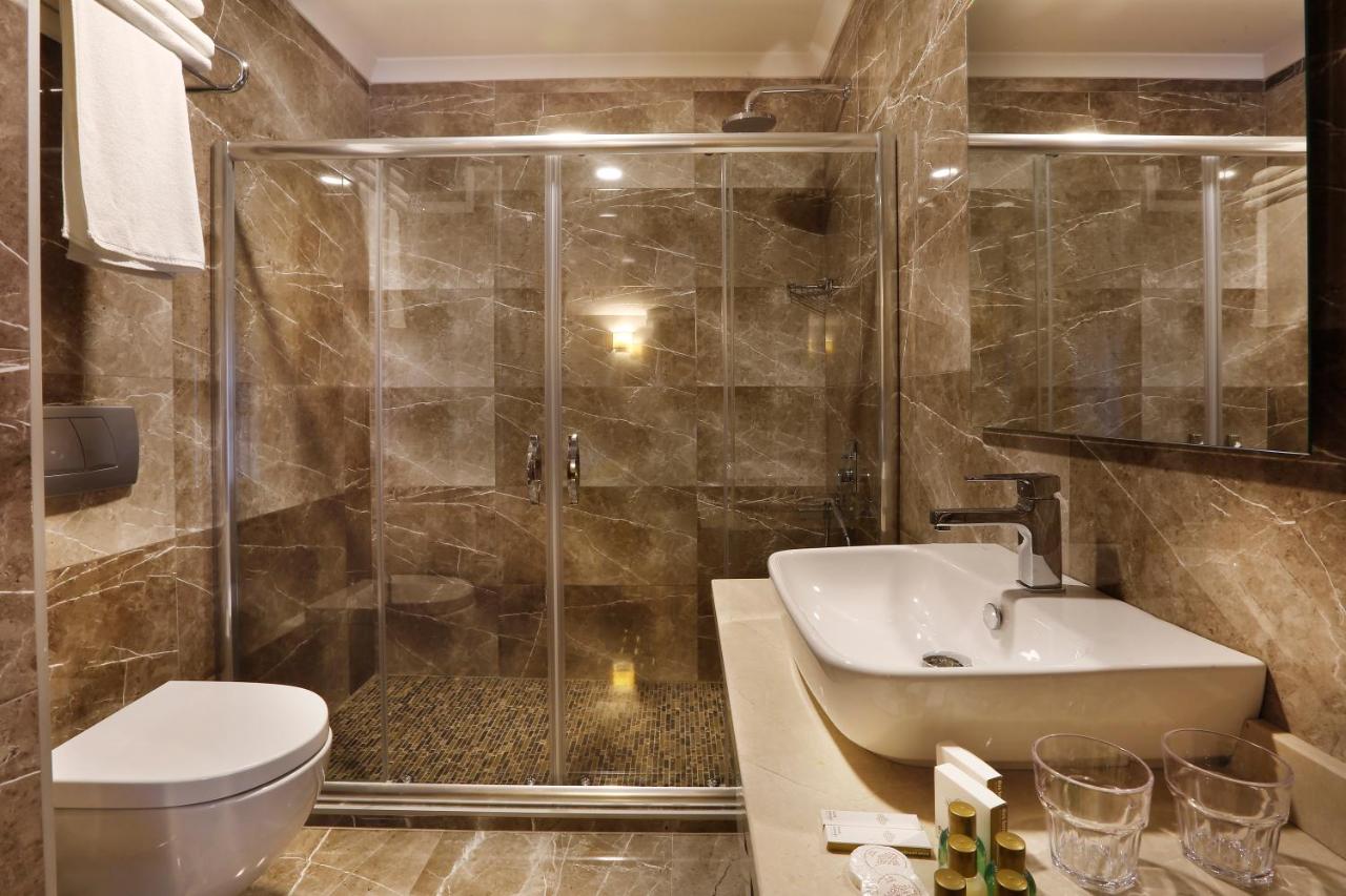 een badkamer met een douche, een toilet en een wastafel bij The White Orient Hotel in Istanbul