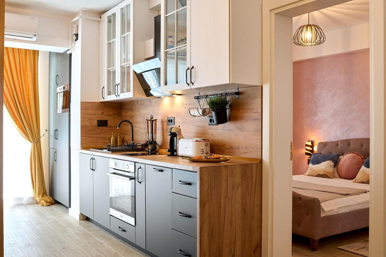een keuken met witte kasten en een bank in een kamer bij La Mer by Infinity Resort & SPA in Mamaia Nord – Năvodari