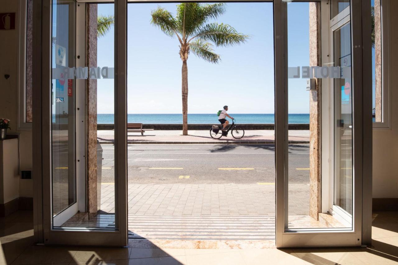 een persoon die op een fiets door een straat met een palmboom rijdt bij Checkin Diamar in Arrecife