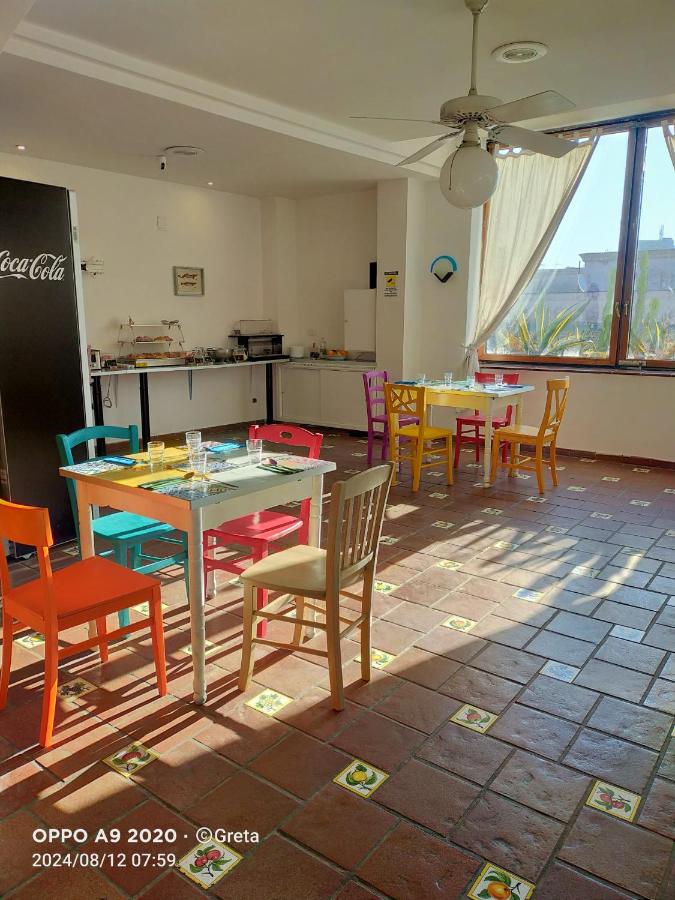 een eetkamer met kleurrijke tafels en stoelen bij Jazz Hotel in Napels