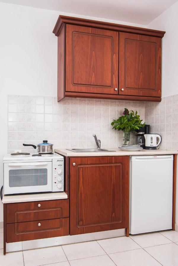 een keuken met houten kasten en een wit apparaat bij Ariadni Palace Apartments in Chersonissos