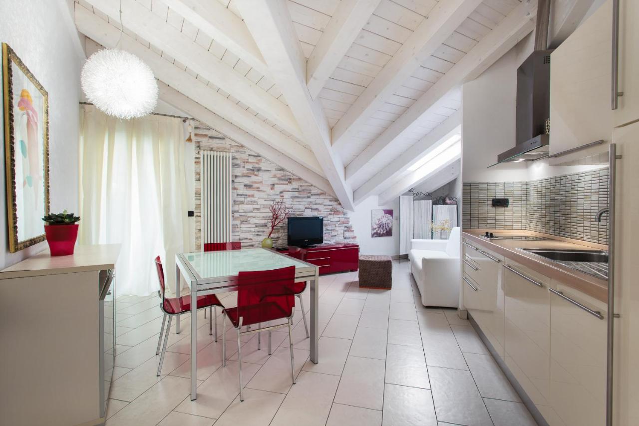 een keuken en eetkamer met een tafel en rode stoelen bij Hotel Flora in Milano Marittima