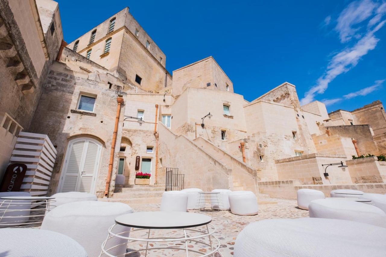 een groep tafels en stoelen voor een gebouw bij Aquatio Cave Luxury Hotel & SPA in Matera