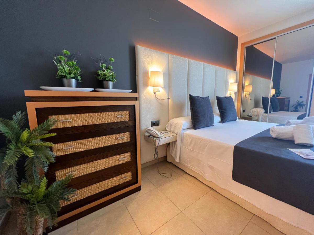een slaapkamer met een bed en twee potplanten bij ON Family Islantilla in Islantilla