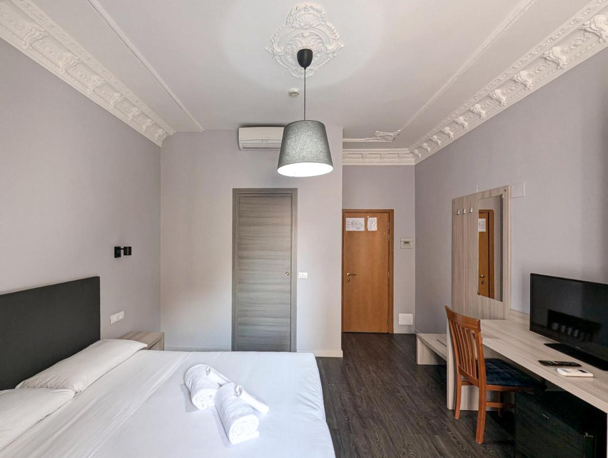 een slaapkamer met een bed, een bureau en een televisie bij Hotel Philia in Rome