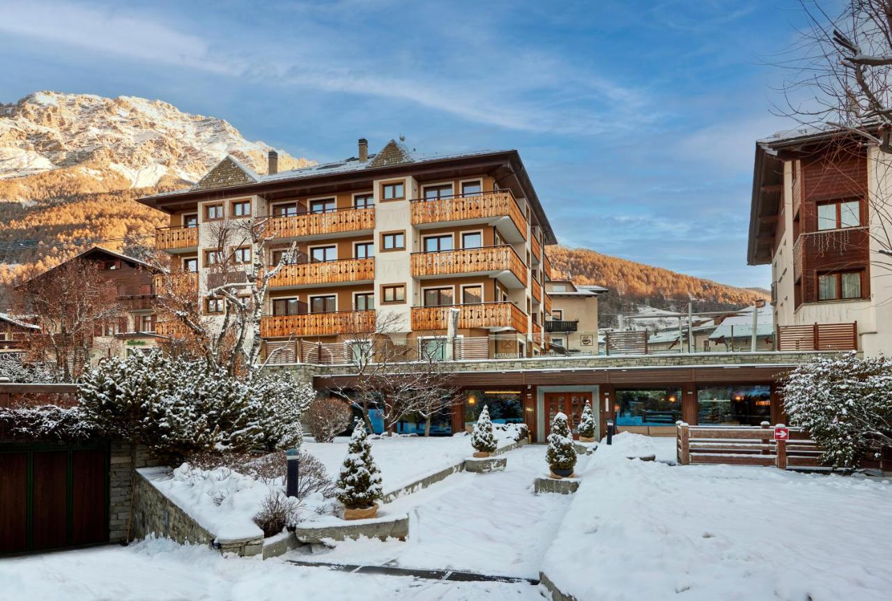 een hotel in de bergen met sneeuw op de grond bij Hotel Rezia in Bormio