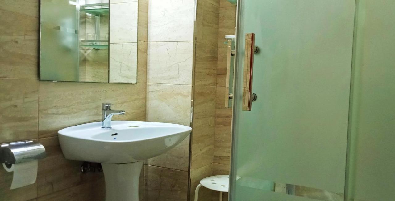 een badkamer met een wastafel, een spiegel en een douche bij Hostal Bahía in Cádiz