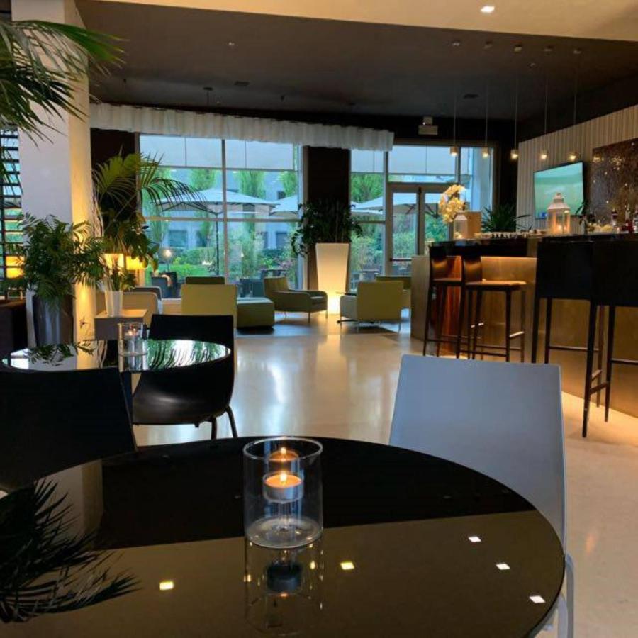 een restaurant met een tafel, stoelen en een bar bij Best Western Plus Hotel Le Favaglie in Cornaredo