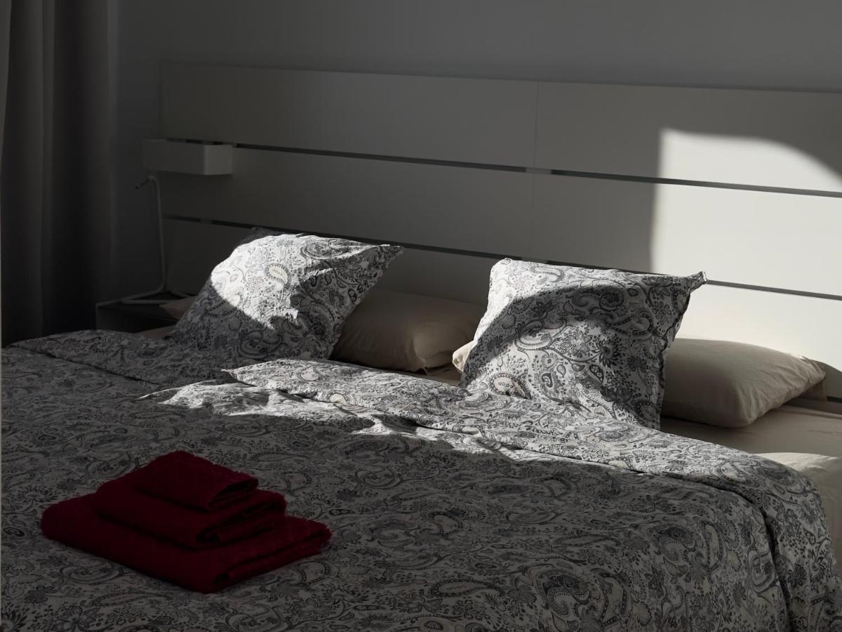 een bed met twee kussens en een rode handdoek erop bij AMADORES BEACH VIEW APARTMENT in Amadores