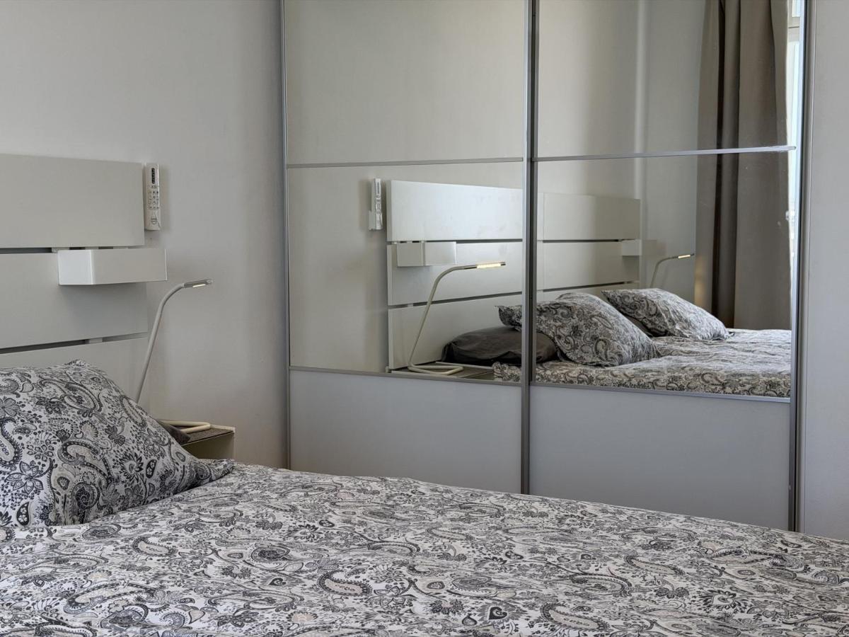 een slaapkamer met een spiegel naast een bed bij AMADORES BEACH VIEW APARTMENT in Amadores