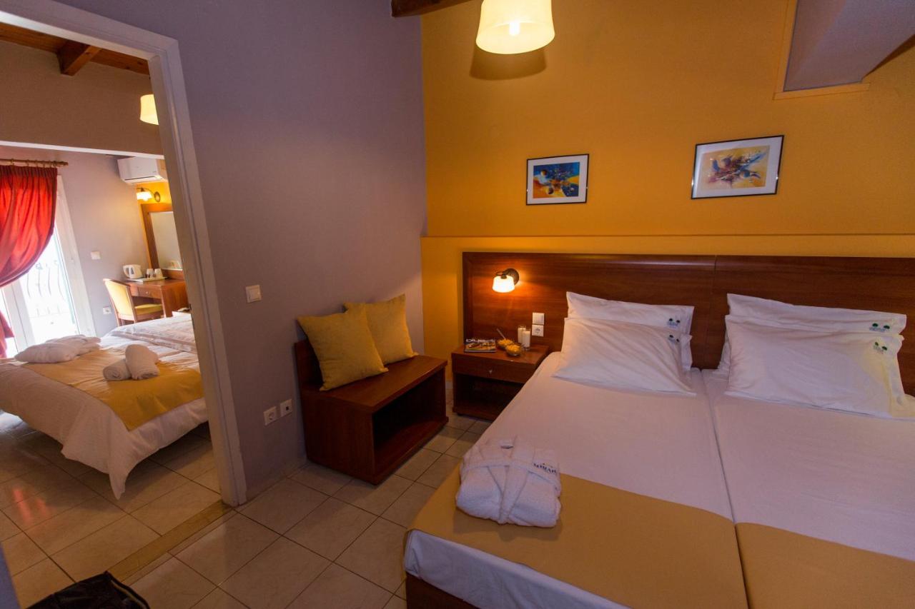 een hotelkamer met een bed en nog een bed en een spiegel bij Mirabel CityCenter Hotel in Argostoli