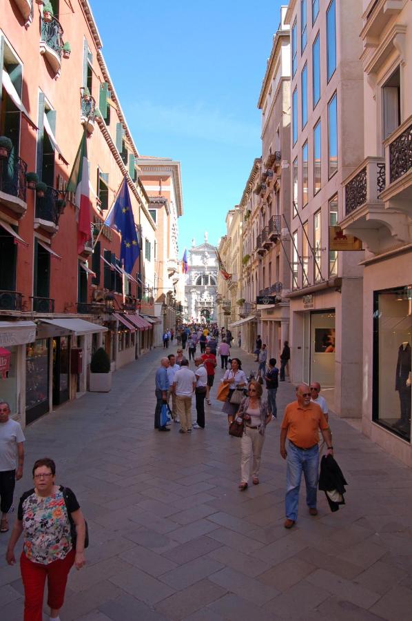 een groep mensen die over straat lopen bij Hotel Torino in Venetië
