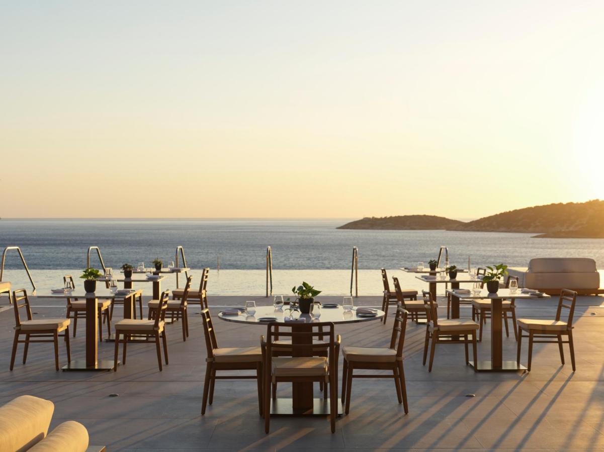 een restaurant met tafels en stoelen op het strand bij InterContinental Crete by IHG in Agios Nikolaos