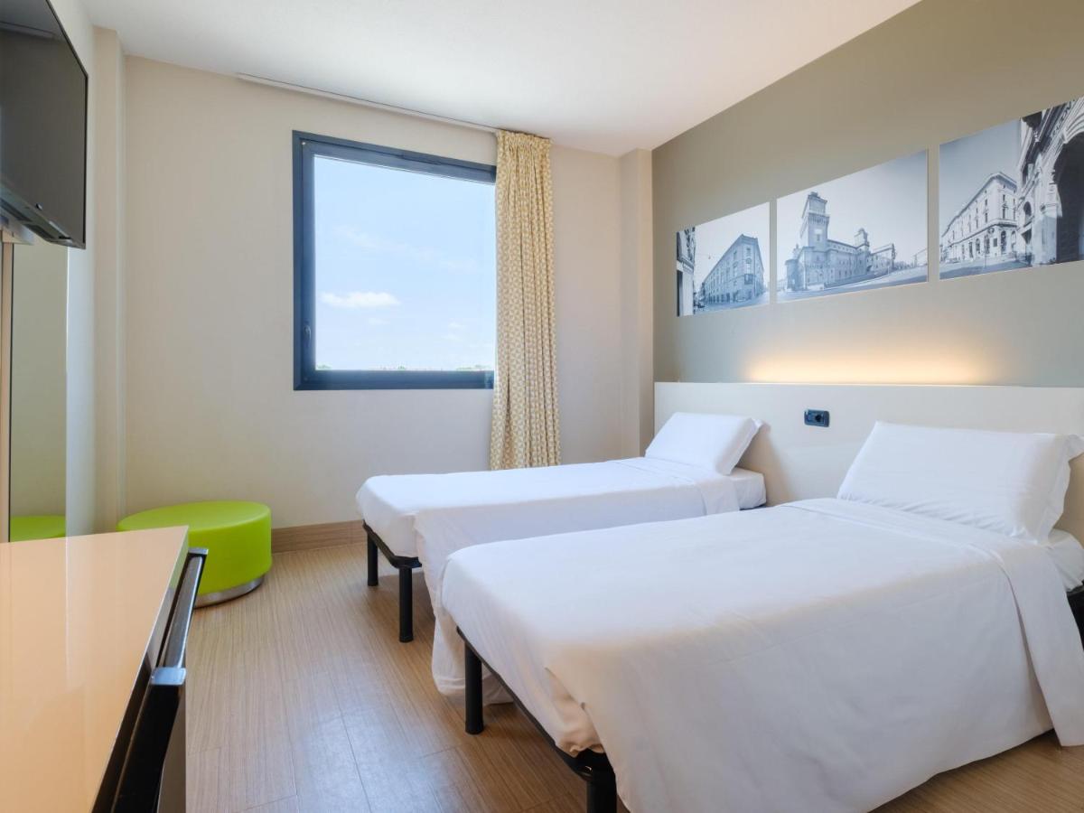 een hotelkamer met twee bedden en een raam bij B&B Hotel Ferrara in Ferrara