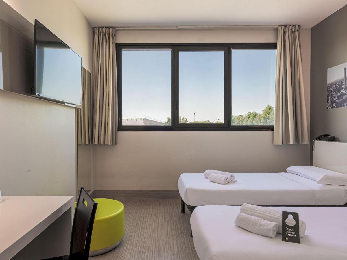 een kamer met drie bedden en een raam bij B&B HOTEL Bologna in Castel Maggiore