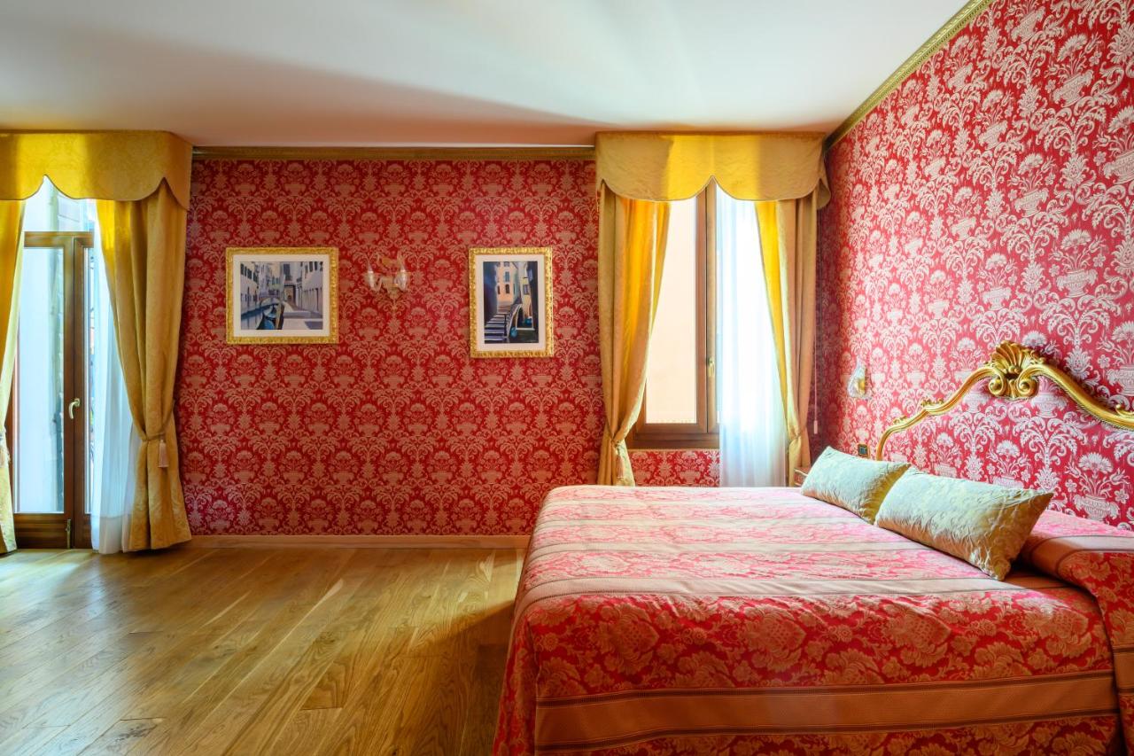 een slaapkamer met rood behang, een bed en ramen bij Residenza Ca' San Marco in Venetië