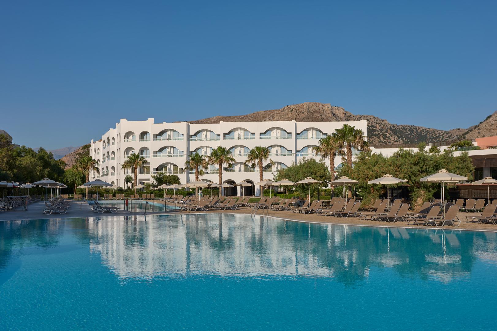 Zwembad omringd door palmbomen — Atlantica Akti Zeus Hotel