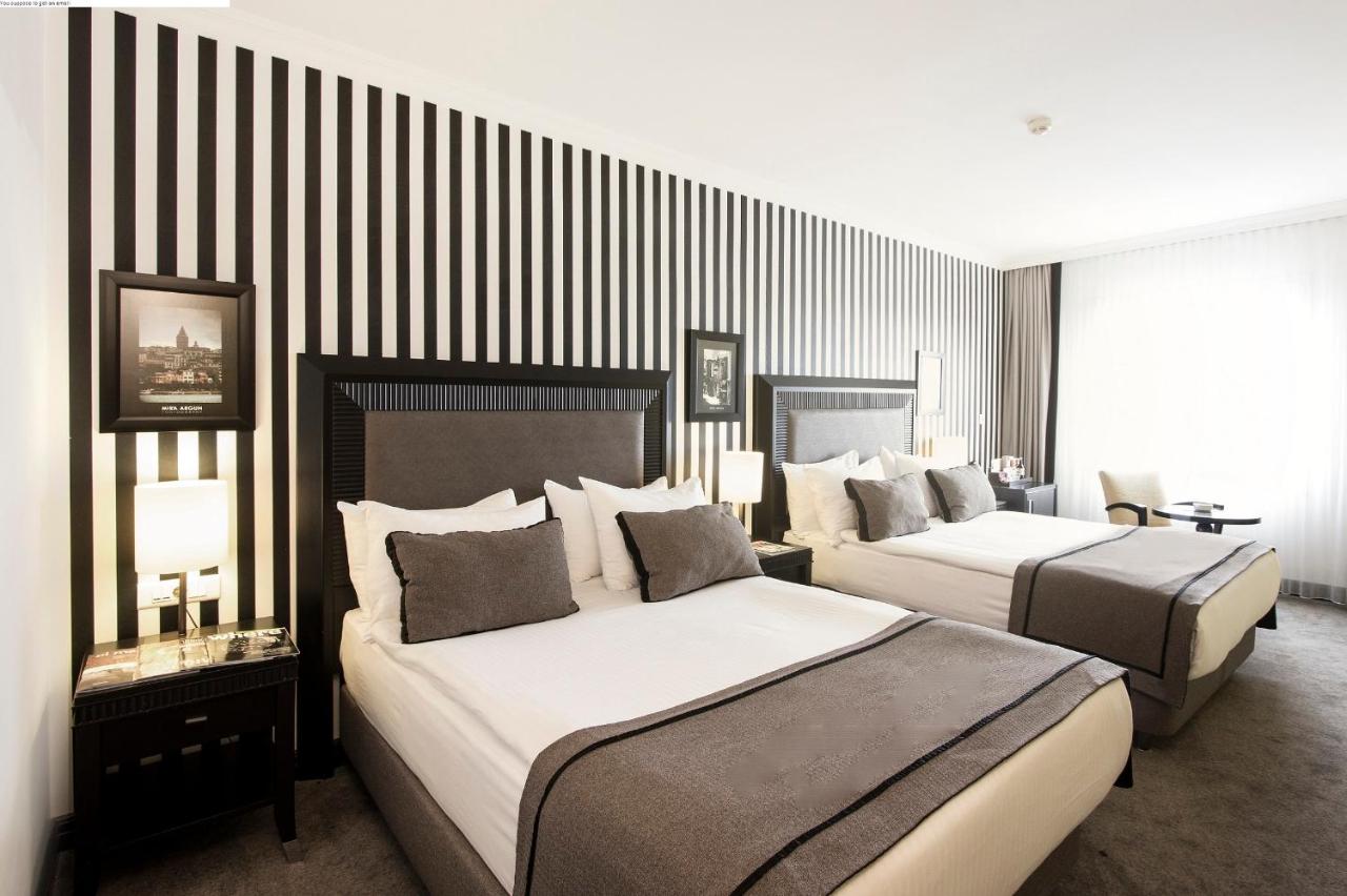 twee bedden in een hotelkamer met zwart-witte strepen bij Avantgarde Urban Taksim in Istanbul