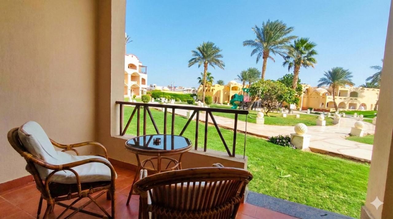 een balkon met stoelen, een tafel en palmbomen bij Regency Plaza Aqua Park and Spa Resort in Sharm El Sheikh
