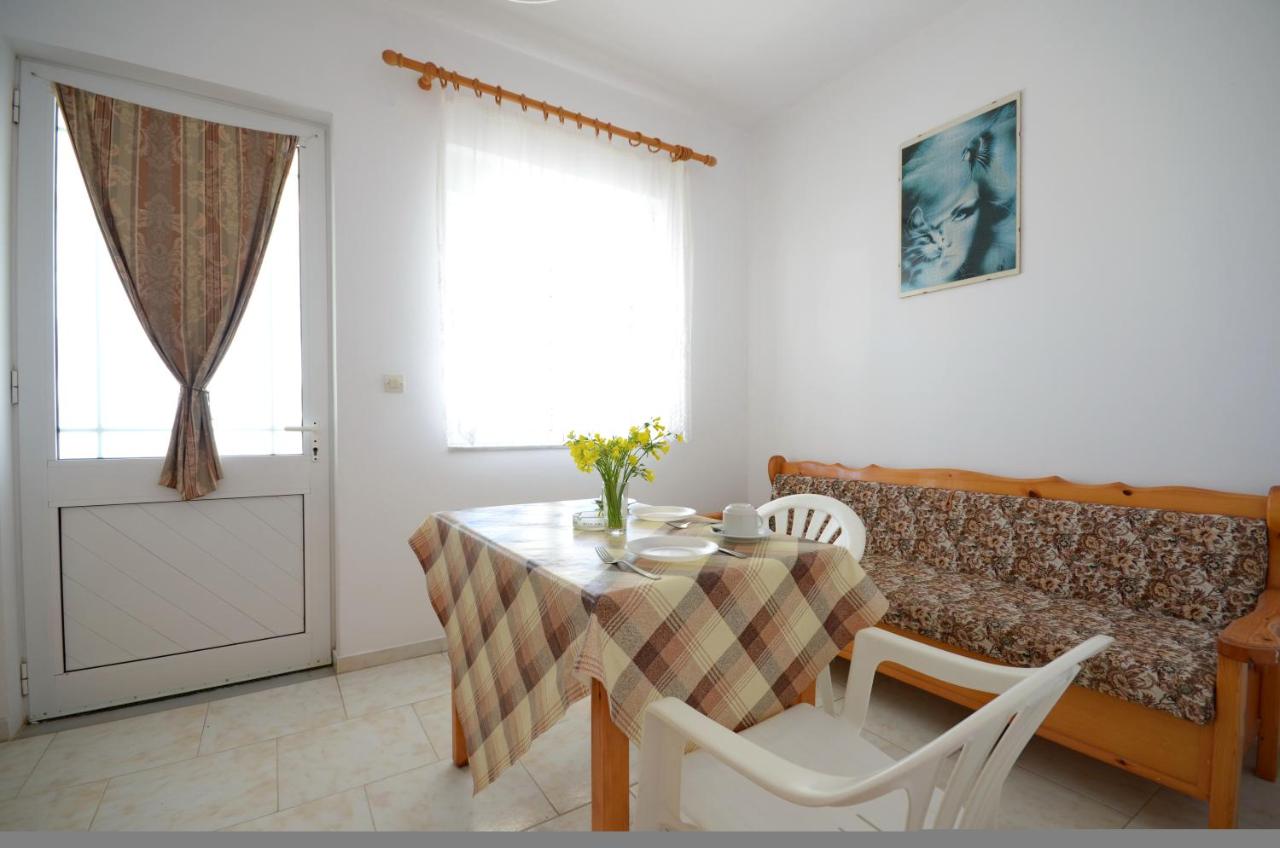 een eetkamer met een tafel en stoelen en een raam bij Studio Anthoula in Kefalos