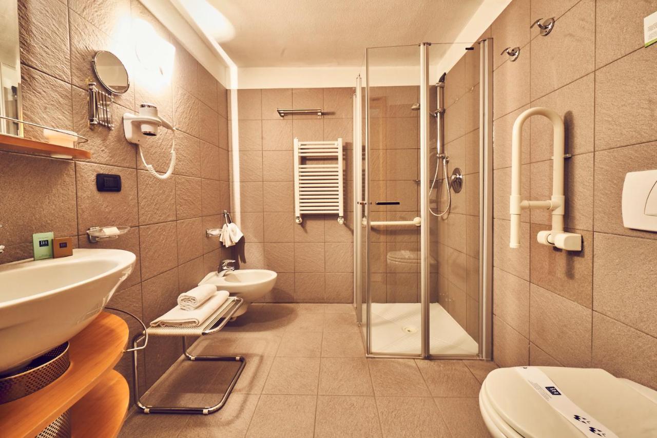 een badkamer met een douche, een toilet en een wastafel bij iH Hotels Courmayeur Mont Blanc in Courmayeur
