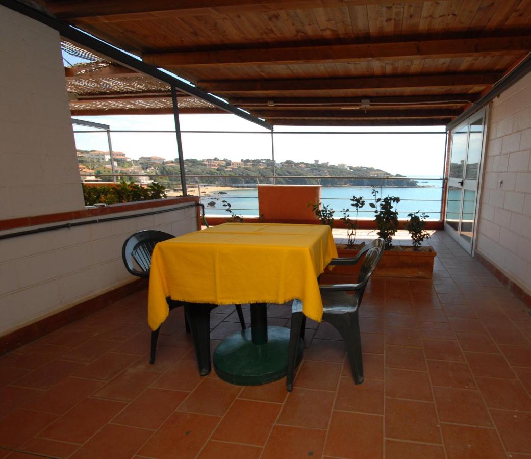 een tafel met een geel tafelkleed op een balkon bij Hotel Baia Del Sorriso in Castiglioncello