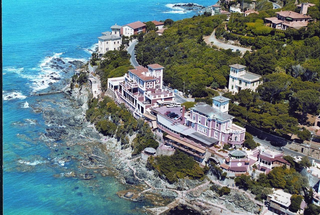 een groep huizen op een heuvel naast de oceaan bij Hotel Baia Del Sorriso in Castiglioncello