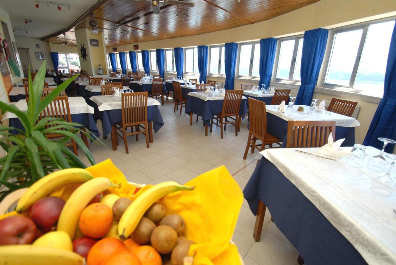 een restaurant met tafels en stoelen met bananen en fruit bij Hotel Baia Del Sorriso in Castiglioncello +70 foto's