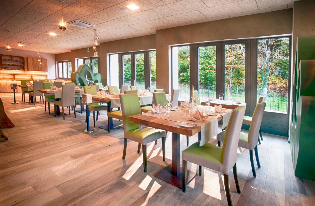 een eetkamer met tafels en stoelen en ramen bij Hotel Cortese in Armeno