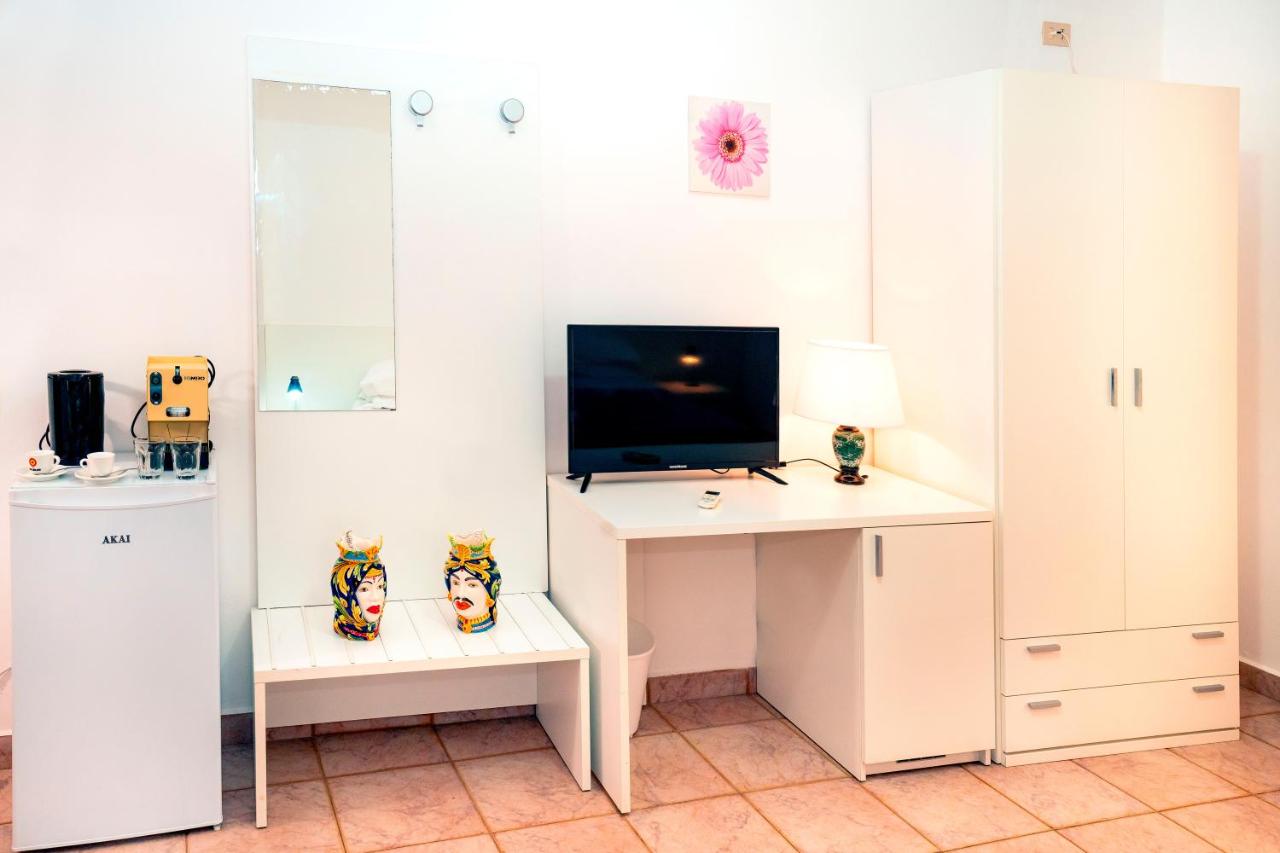 een kamer met een bureau, een tv en een computer bij Hotel Fernanda in Letojanni