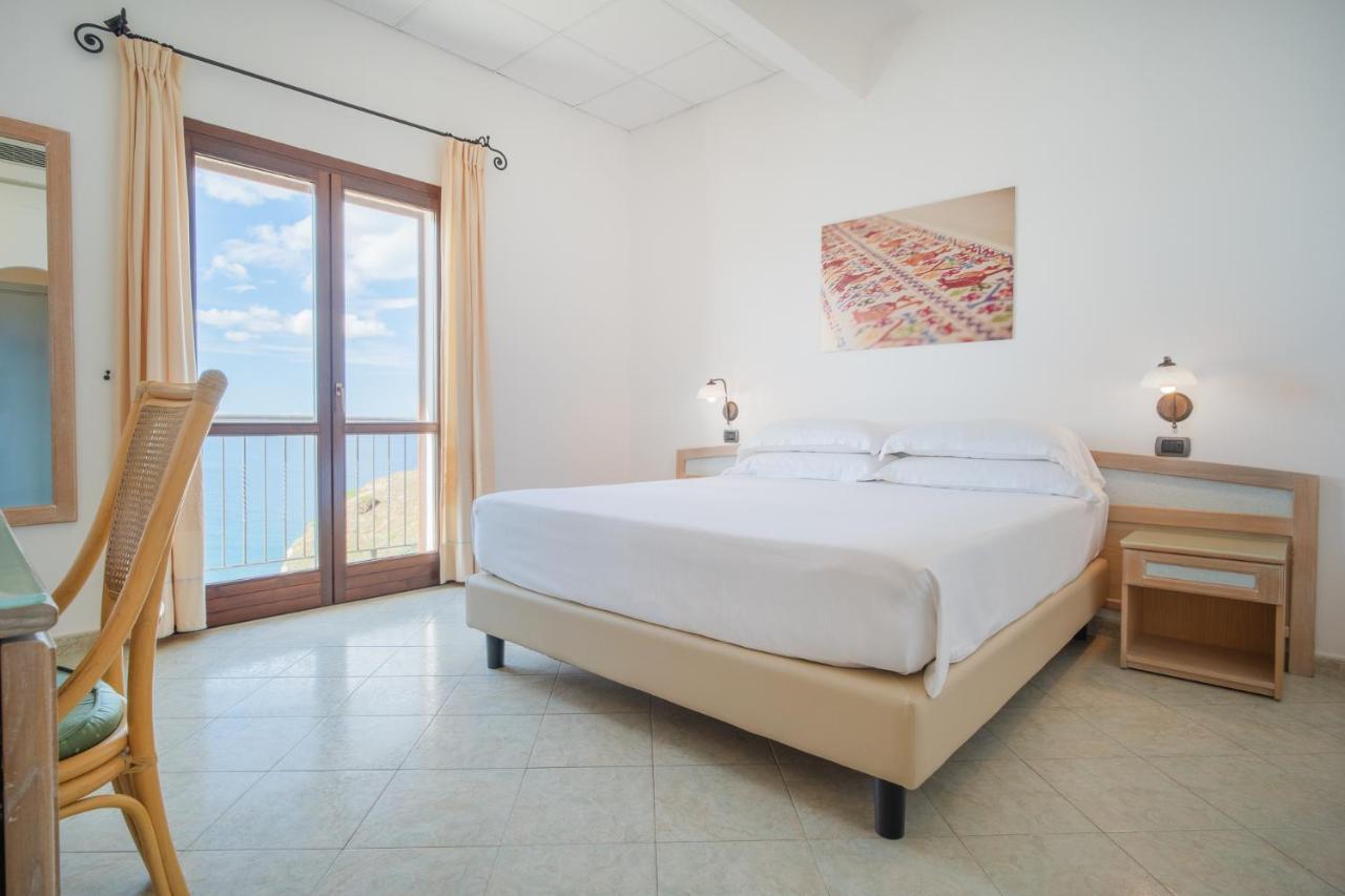 een witte slaapkamer met een bed en een balkon bij Felix Hotels - Hotel La Baja in Santa Caterina