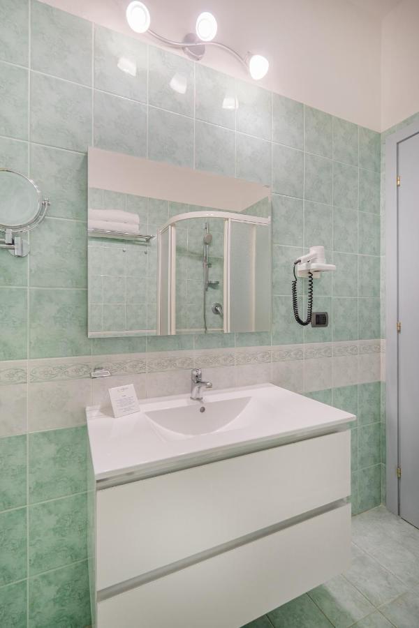 een badkamer met een witte wastafel en een spiegel bij Felix Hotels - Hotel La Baja in Santa Caterina