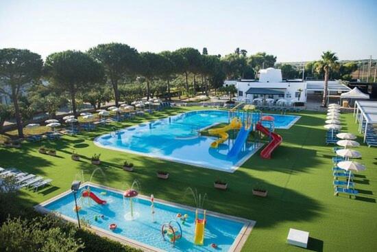 een groot zwembad met een glijbaan en een waterpark bij Color Dolmen Family Village in Minervino di Lecce