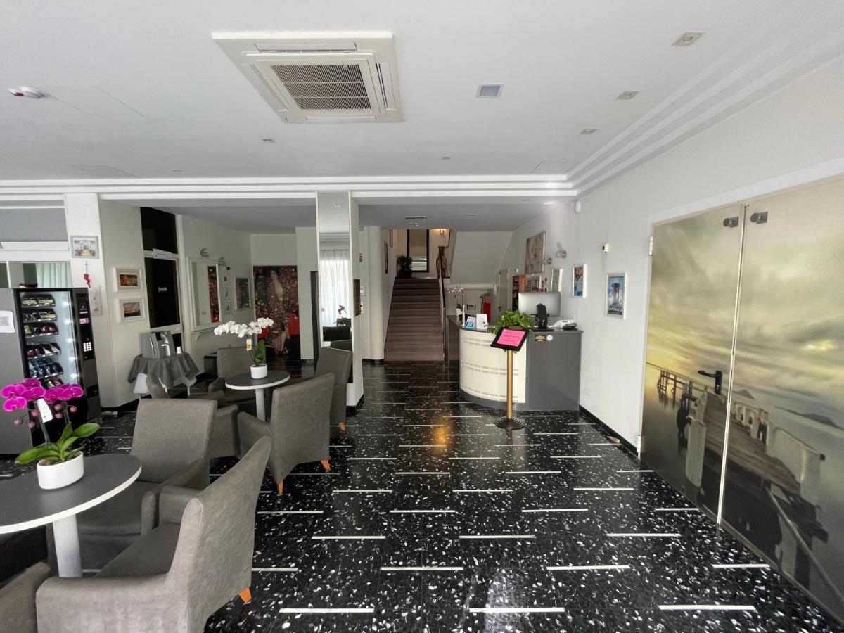 Een hotellobby met tafels en stoelen. bij HOTEL D'ANNUNZIO in Cattolica
