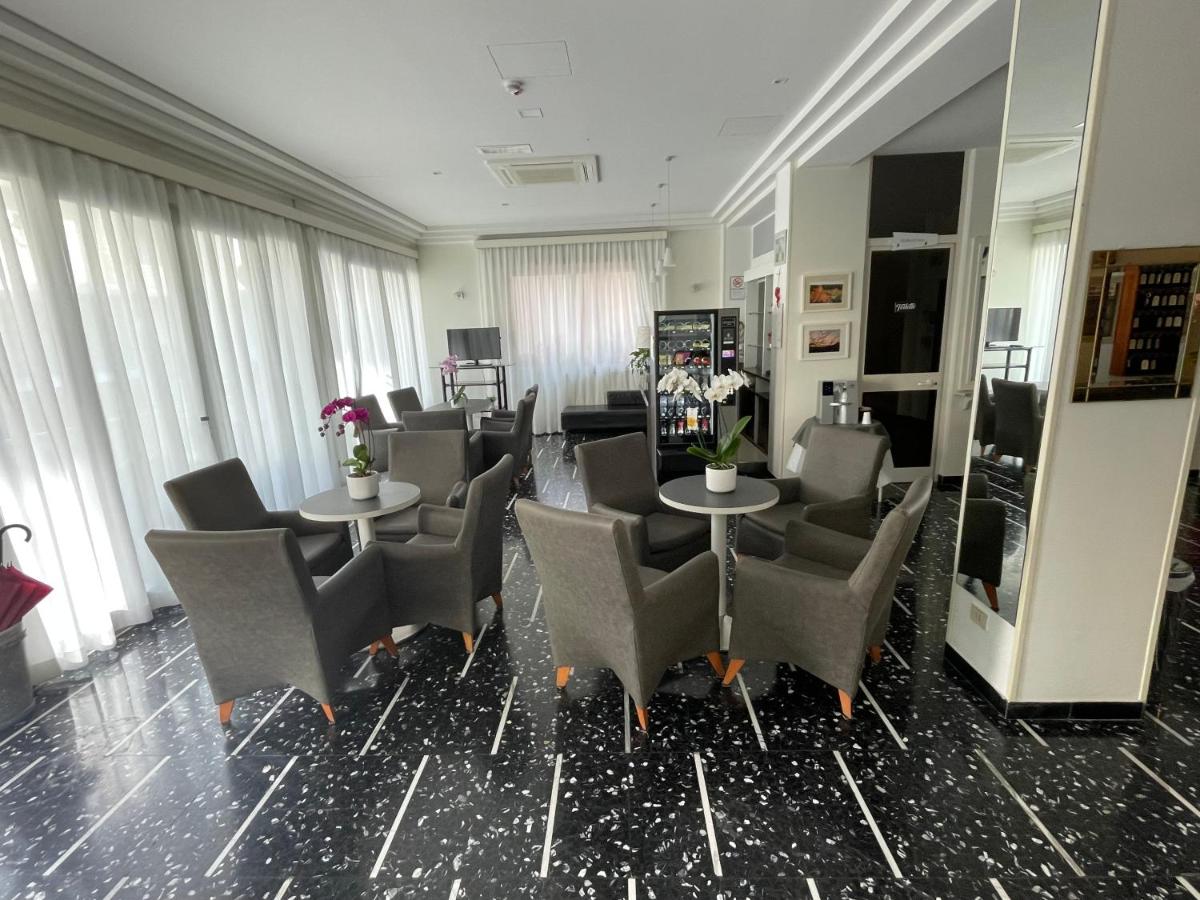 een wachtkamer met stoelen en tafels en een spiegel bij HOTEL D'ANNUNZIO in Cattolica